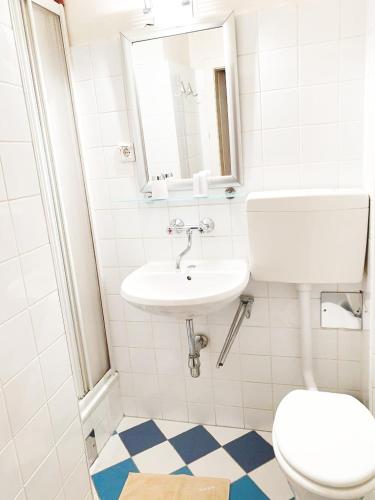ein weißes Bad mit einem Waschbecken und einem WC in der Unterkunft Pension Huber - Apartement Wien 20 in Wien