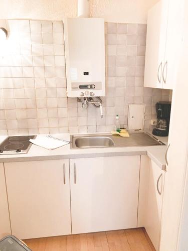 una cocina con armarios blancos y fregadero en Pension Huber - Apartement Wien 20 en Viena