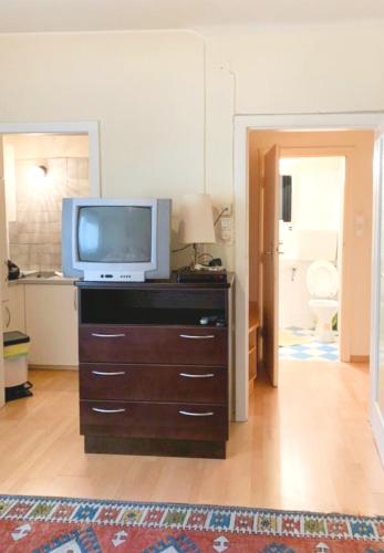 a living room with a television on a dresser at Pension Huber - Apartement Wien 20 in Vienna