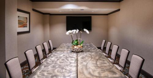 a dining room table with chairs and a vase of flowers at One Ocean Resort and Spa in Atlantic Beach