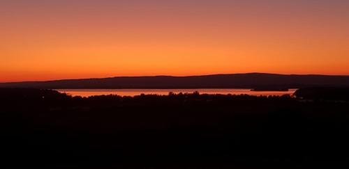 a sunset over a body of water with mountains at BARR AN CHNOIC HOLIDAY LETTINGS in Tipperary