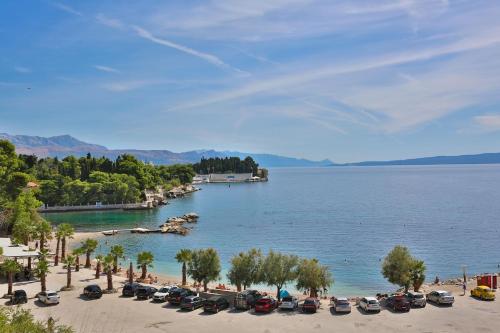 a group of cars parked on a beach next to a body of water at Apartment Angelina in Split