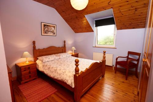 a bedroom with a bed and a chair and a window at Mount Brandon Cottages Graiguenamanagh in Graiguenamanagh