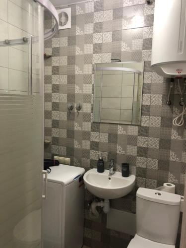 ein Badezimmer mit einem WC, einem Waschbecken und einem Spiegel in der Unterkunft Уютная Квартира в центре in Tschernihiw