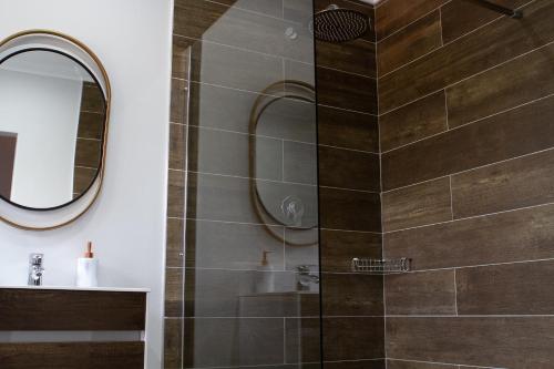 een douche met een glazen deur in de badkamer bij The Stables, Beaulieu Kyalami in Midrand