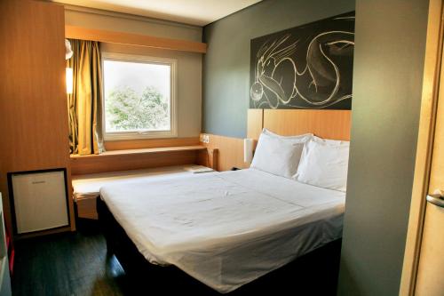 ein Hotelzimmer mit einem Bett und einem Fenster in der Unterkunft ibis Bacabal in Bacabal