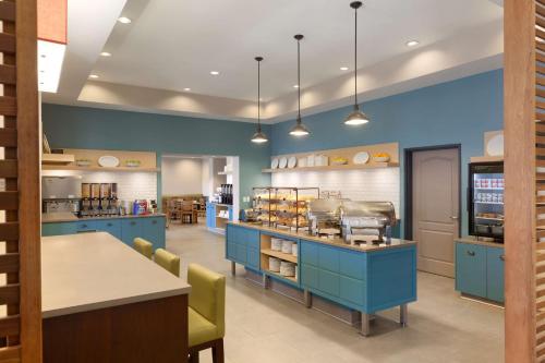 a kitchen with blue cabinets and a counter with food at Country Inn & Suites by Radisson, Bloomington at Mall of America, MN in Bloomington