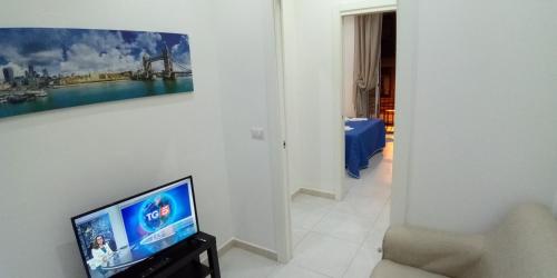 a living room with a television and a painting on the wall at InBlu in Bari