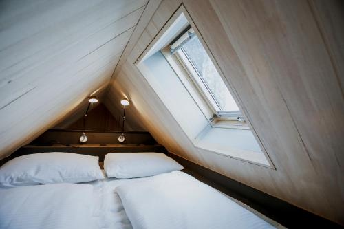 two beds in a small room with a window at AUGUST Dachgeschosswohnung im jüdischen Viertel in Hohenems