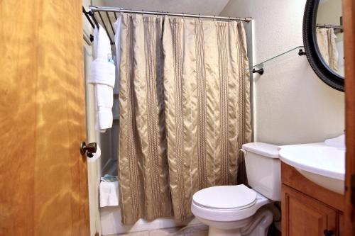 a bathroom with a shower curtain and a toilet at The River House in San Marcos