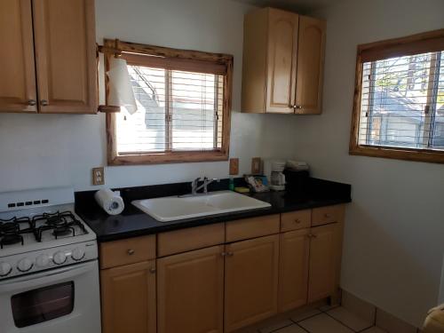 a kitchen with a sink and a stove and window at Big Bear Frontier in Big Bear Lake