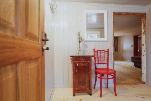 a red chair sitting next to a table in a room at MINA Stadtwohnung im Jüdischen Viertel in Hohenems