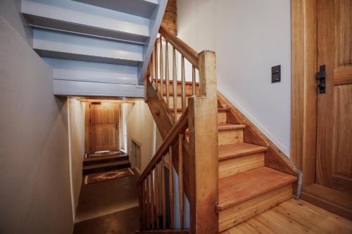 a wooden staircase in a house with a wooden door at MINA Stadtwohnung im Jüdischen Viertel in Hohenems