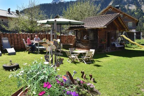 two people sitting at a table in a garden at Kinderbauernhof in Schoppernau