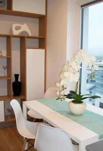 a dining room with a table with a vase of flowers at Aqua Apartments Sunset in Reda