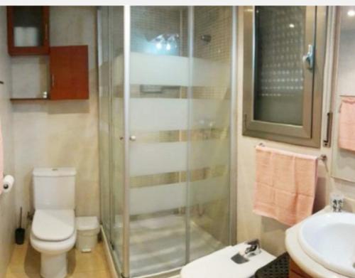 uma casa de banho com um chuveiro, um WC e um lavatório. em APARTAMENTO EN SEGUNDA LINEA DE MAR, WIFI & A.C em Cubelles