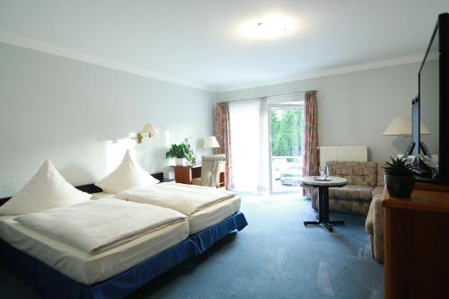 um quarto de hotel com uma cama e um sofá em Hotel-Restaurant Pfeffermühle Balingen em Balingen