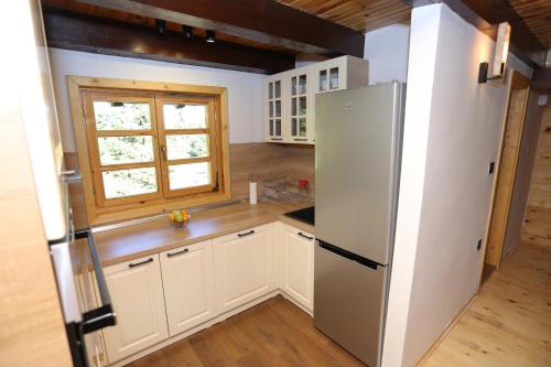 Tara Cottage في باغينا باستا: مطبخ مزود بثلاجة ونافذة