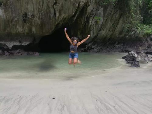 a woman jumping into the water on the beach at Cashew Nut Bungalow, Ko Mook in Koh Mook