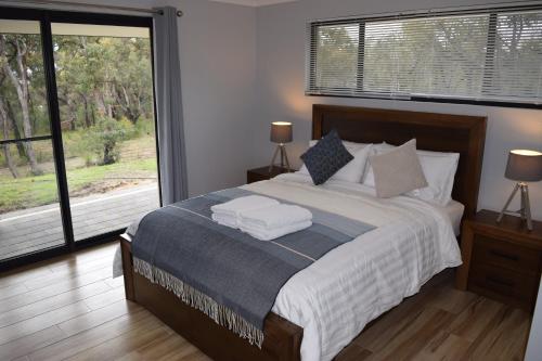 a bedroom with a large bed and a large window at Eagle Bay House in Dunsborough