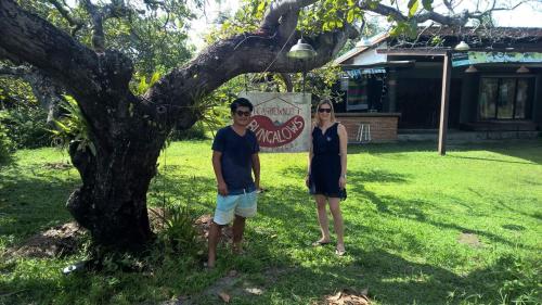 a man and a woman standing next to a tree at Cashew Nut Bungalow, Ko Mook in Koh Mook