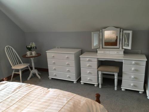 a bedroom with a dresser and a desk with a mirror at The Loft in Congleton