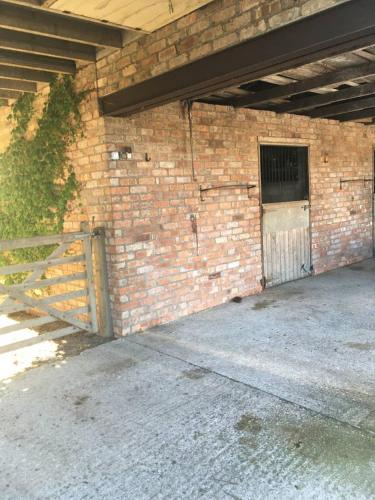 a brick building with a gate and a door at The Loft in Congleton