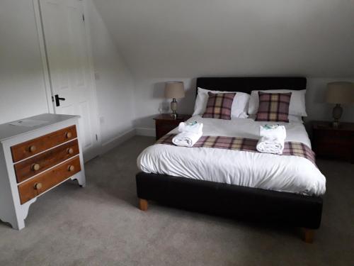 a bedroom with a large bed and a dresser at White Horse Inn in Andover