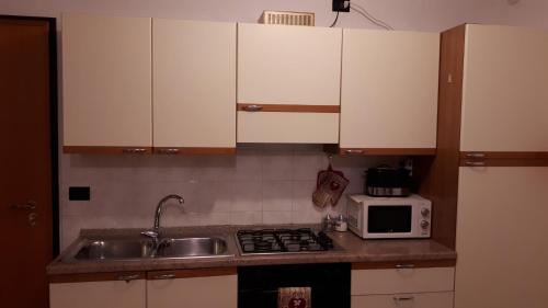 a kitchen with a sink and a microwave at Magic Riva Apartment in Riva del Garda