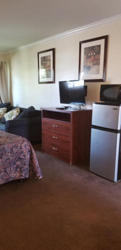 a hotel room with a bed and a refrigerator at Sierra Crossing Motel in Bloomington