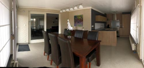 a dining room with a wooden table and chairs at Vivere in Houthalen-Helchteren