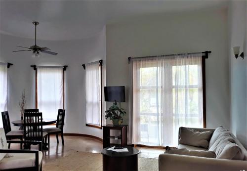 a living room with a couch and chairs and windows at Brahma Blue Resort in San Pedro