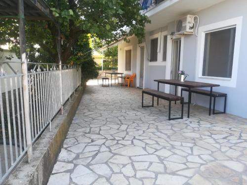 eine Terrasse mit Bänken, einem Tisch und einem Baum in der Unterkunft Poulithra Beach in Poúlithra