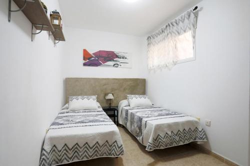 Duas camas num quarto com paredes brancas em Ifara 22 em San Isidro