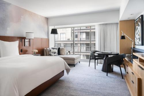 シアトルにあるフォー シーズンズ ホテル シアトルのベッドとデスクが備わるホテルルームです。