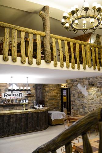 a dining room with a bar and a chandelier at Hotel Ragnar in Nizhnyaya Alekseyevka
