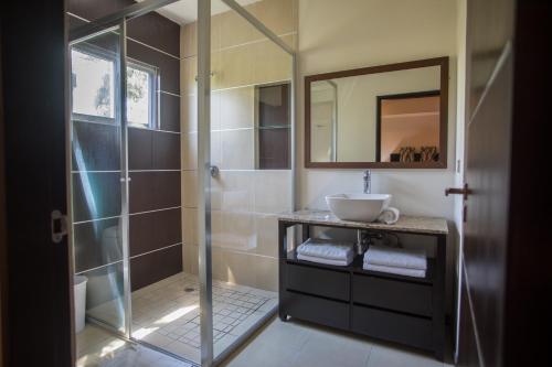 a bathroom with a glass shower and a sink at San Pedro Hotel, 5ta Avenida in Playa del Carmen