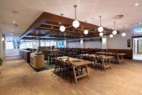 Un restaurante con mesas y sillas y un bar. en Wentworth Hotel, en Sídney