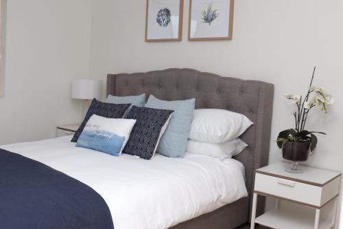 1 dormitorio con 1 cama con almohadas azules y blancas en Waterviews on Marine Pde 3/32, en The Entrance