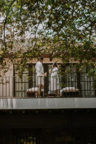 two people in white robes standing on a balcony at Hotel Museo Spa Casa Santo Domingo in Antigua Guatemala