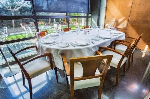 a table with chairs and a white table cloth on it at Best Western Plus Hotel Alfa Aeropuerto in Barcelona