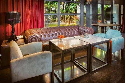 a living room with a leather couch and chairs at Best Western Plus Hotel Alfa Aeropuerto in Barcelona