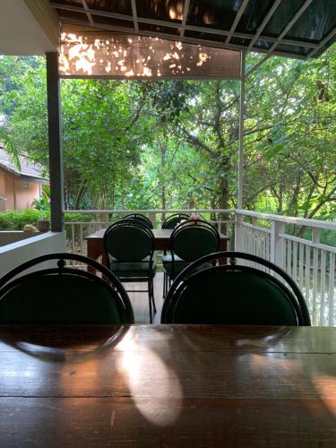 a wooden table and chairs on a porch at Khao Yai Cottage in Mu Si