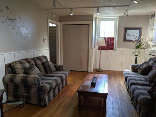 a living room with two couches and a coffee table at Spruce Lane Lodge and Cottages in Smoketown