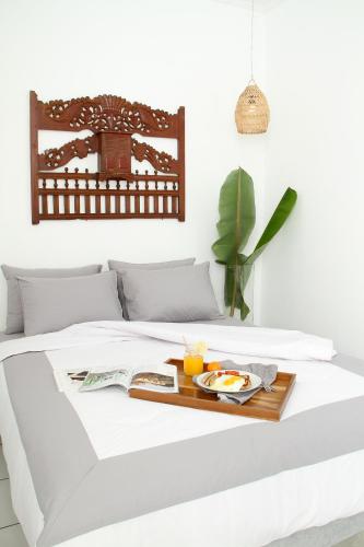 a bed with a tray of food on it at Boscha Villas 102 in Bandung
