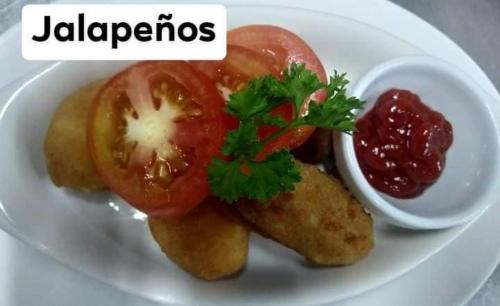 a white plate of food with tomatoes and ketchup at Bella's Beach Resort (A) in Bauang