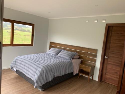 a bedroom with a bed and a window at Casa Familiar Puerto Varas in La Ensenada