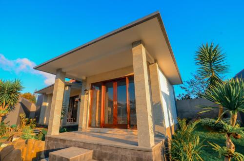 a house on the beach with palm trees at Villa Danu Kintamani in Kintamani