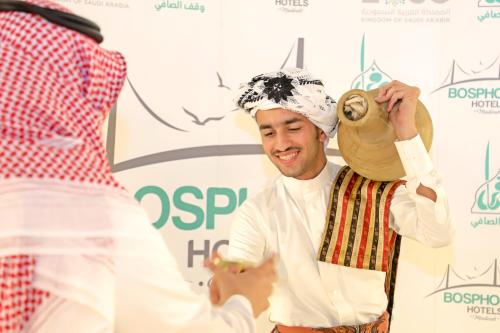 a man wearing a hat and holding a teapot at Le Bosphorus Hotel Two in Al Madinah