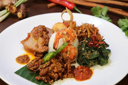 a plate of food on a table at Discovery Kartika Plaza Hotel in Kuta